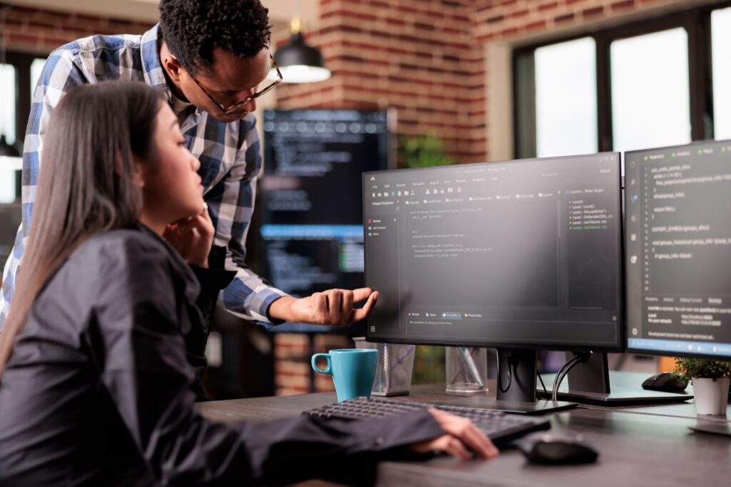 Man and woman discussing html code and discovers errors on computer