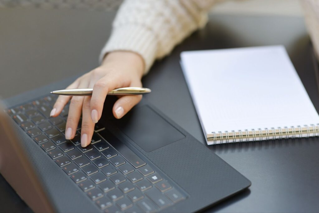 Close up of woman typing on laptop keyboard